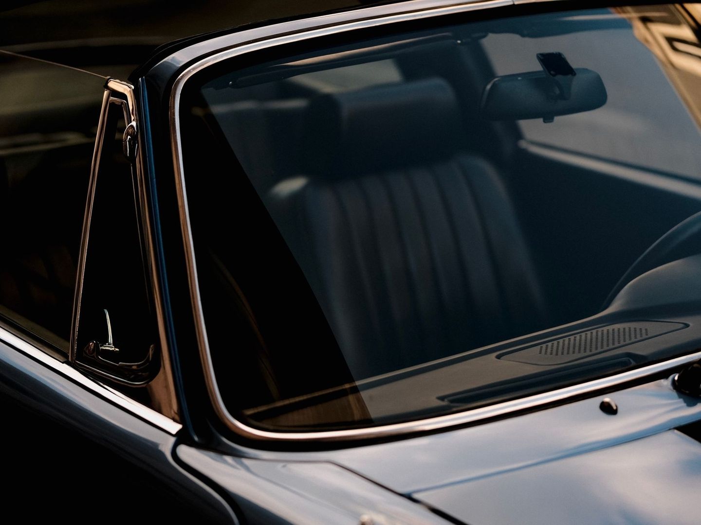 Close-up of a classic car windshield and chrome window trim