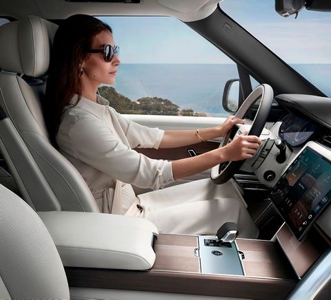 Woman seated upright at the wheel in a spacious car interior