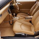 Tan leather car interior with smooth, intact seats and dashboard