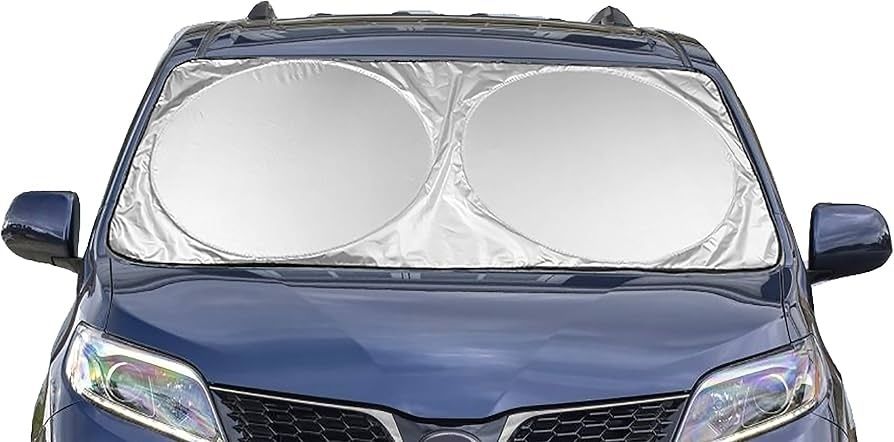 Reflective windshield sunshade covering the front of a blue car